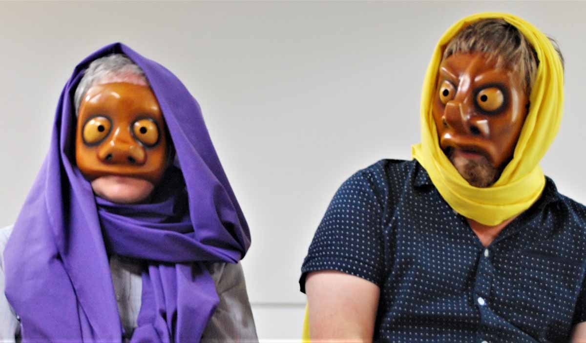 man and woman improvisers wear masks during improv training in London